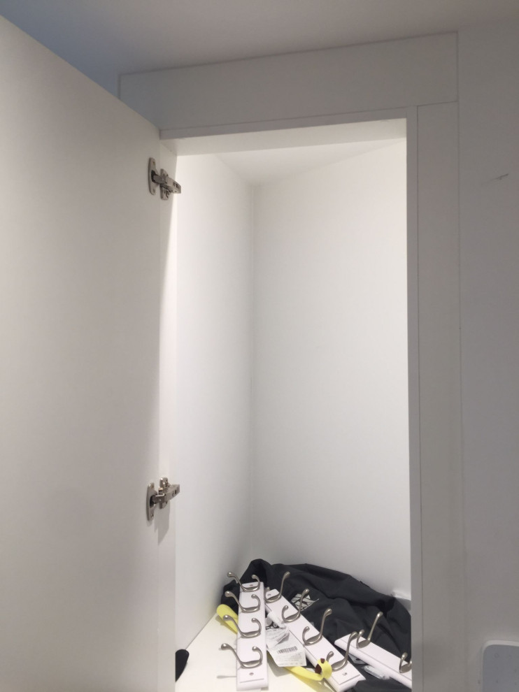 Immagine di un piccolo armadio incassato unisex classico con ante lisce, ante bianche, pavimento in laminato, pavimento marrone e soffitto ribassato