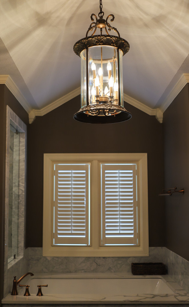 Inspiration for a large transitional master white tile and marble tile porcelain tile and gray floor corner shower remodel with shaker cabinets, dark wood cabinets, an undermount tub, a one-piece toilet, brown walls, an undermount sink, quartz countertops, a hinged shower door and white countertops