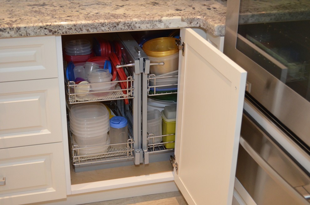 Mid-sized transitional l-shaped porcelain tile enclosed kitchen photo in Toronto with an undermount sink, raised-panel cabinets, white cabinets, granite countertops, beige backsplash, stainless steel appliances and an island