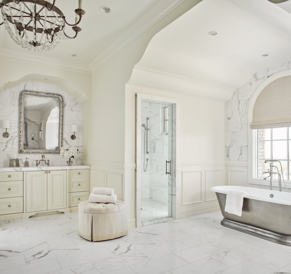 This is an example of a mediterranean master wet room bathroom in Phoenix with marble floors, recessed-panel cabinets, white cabinets, a freestanding tub, white walls, an undermount sink, white floor, a hinged shower door, white benchtops, a single vanity, a built-in vanity and panelled walls.