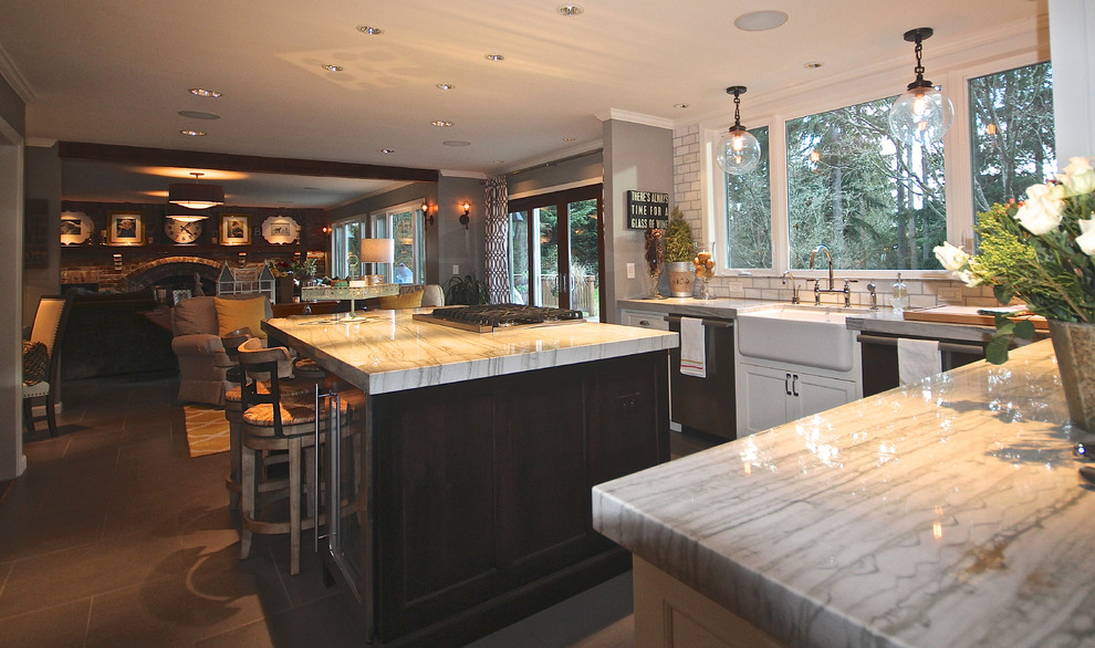 Expansive transitional open plan kitchen in Seattle with a farmhouse sink, raised-panel cabinets, white cabinets, quartzite benchtops, white splashback, subway tile splashback, stainless steel appliances and porcelain floors.