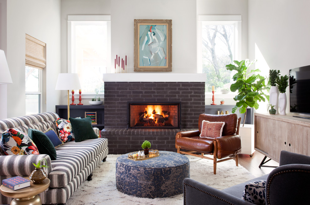 Transitional living room in Austin with white walls, a ribbon fireplace, a brick fireplace surround and a freestanding tv.