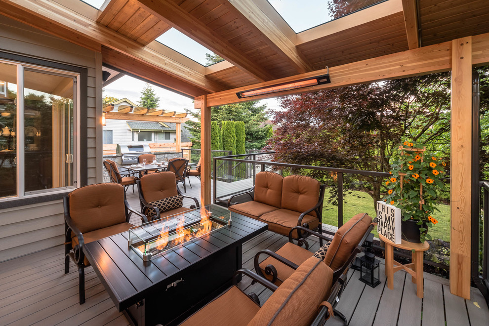 Photo of a mid-sized contemporary backyard deck in Vancouver with an awning.