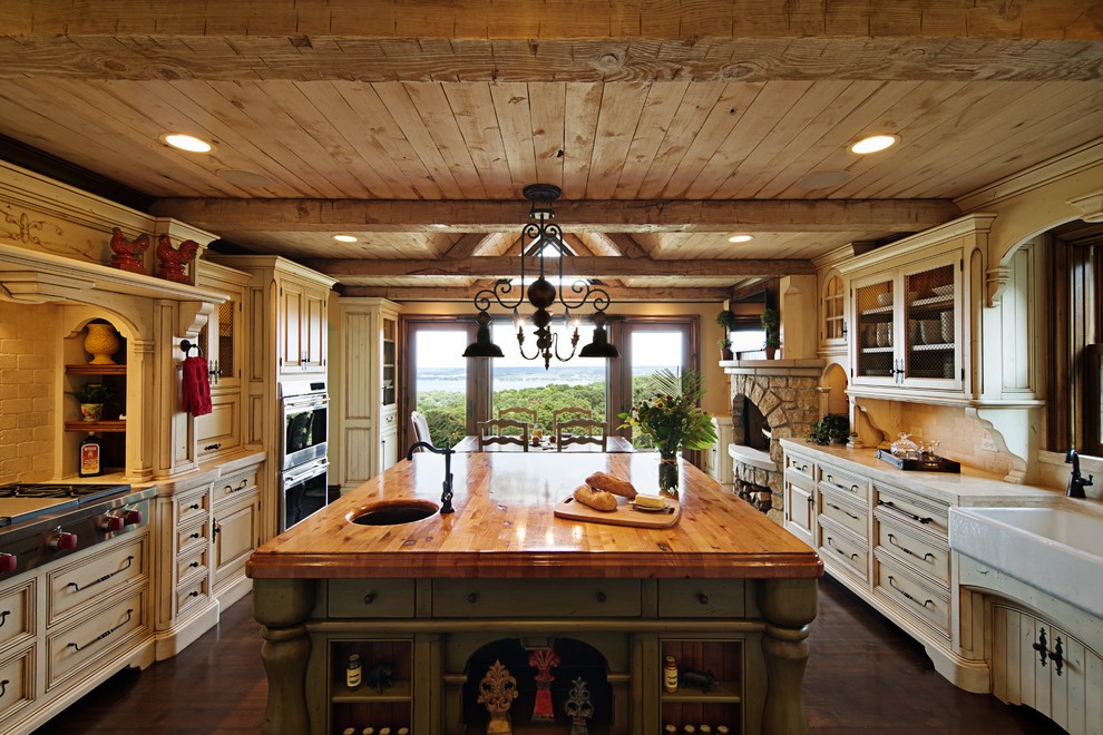 Inspiration for a rustic u-shaped eat-in kitchen remodel in Chicago with a farmhouse sink, beaded inset cabinets, white cabinets, limestone countertops, beige backsplash, subway tile backsplash and paneled appliances