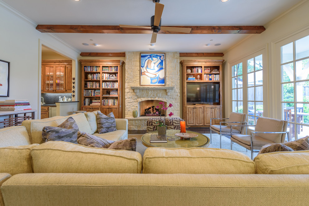 Large traditional open concept family room in Dallas with a home bar, beige walls, dark hardwood floors, a standard fireplace, a stone fireplace surround, a freestanding tv and brown floor.
