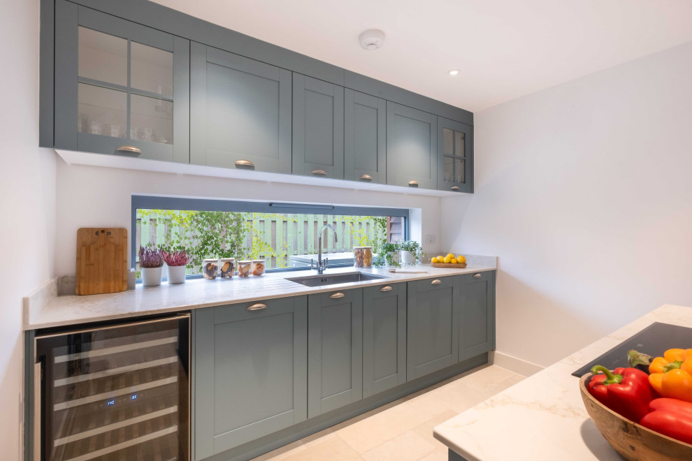 Medium sized contemporary kitchen in Gloucestershire with an integrated sink, shaker cabinets, blue cabinets, engineered stone countertops, ceramic flooring, beige floors and white worktops.