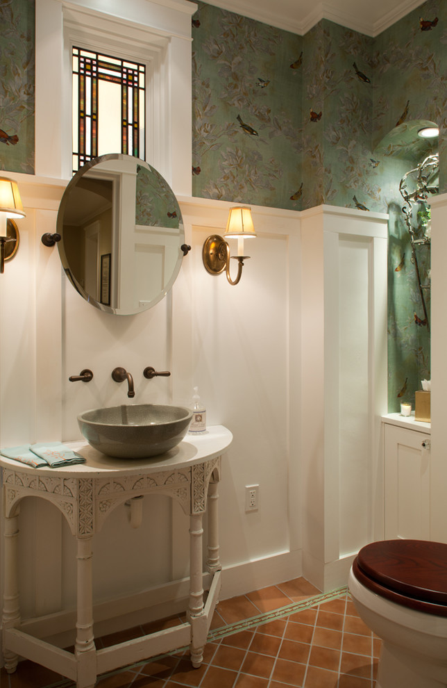 This is an example of an arts and crafts powder room in San Diego with a vessel sink, furniture-like cabinets, multi-coloured walls and terra-cotta floors.