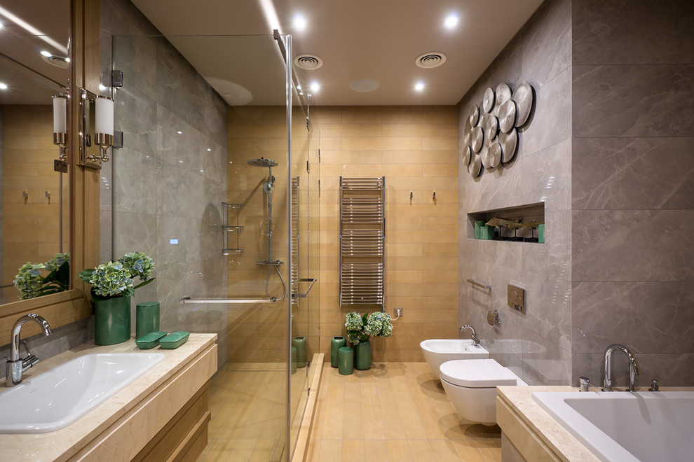 Inspiration for a contemporary master bathroom in Moscow with medium wood cabinets, a corner shower, a bidet, brown tile, gray tile and a drop-in sink.