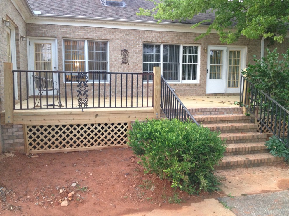 Example of a mid-sized transitional backyard deck design in Raleigh