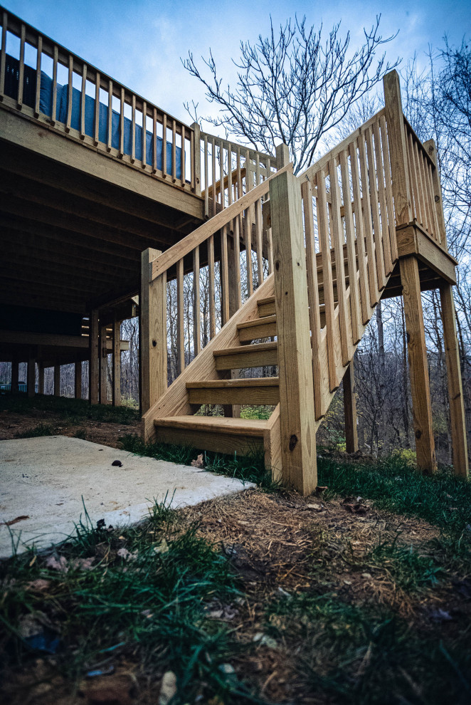 Design ideas for a mid-sized arts and crafts backyard and ground level deck in Cincinnati with wood railing.