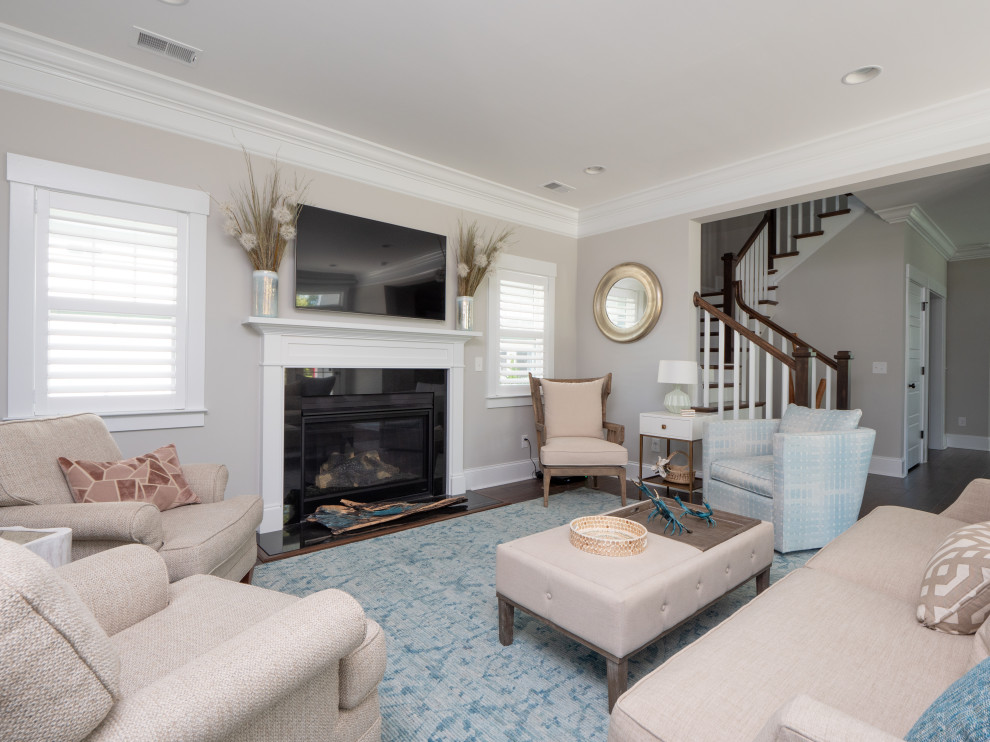 Inspiration for a large beach style enclosed living room in Charleston with grey walls, dark hardwood floors, a standard fireplace, a tile fireplace surround, a wall-mounted tv and brown floor.