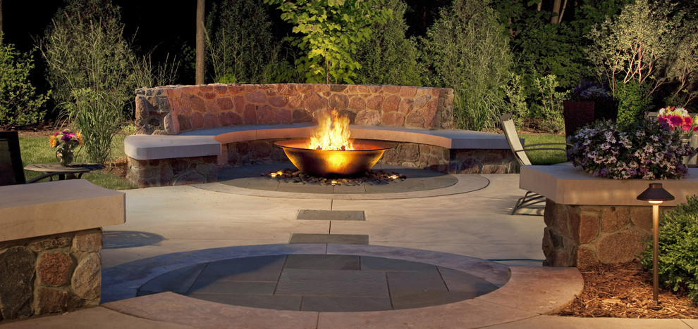 Large arts and crafts backyard patio in Milwaukee with a fire feature and natural stone pavers.