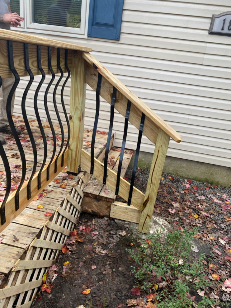 Example of a mid-sized classic backyard ground level wood railing deck design with no cover