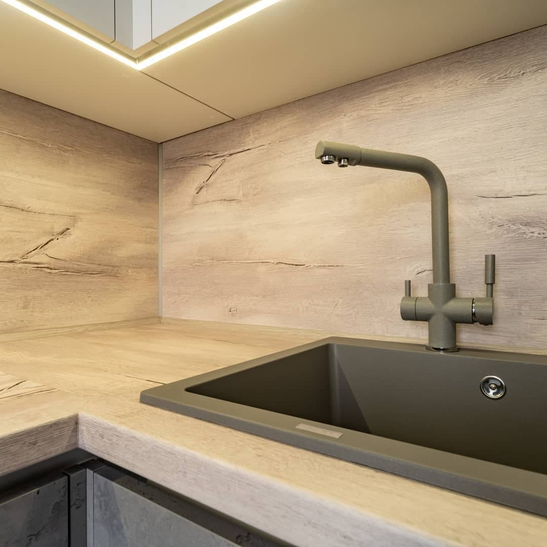 Угловая встроенная кухня с белыми глянцевыми и каменными фасадами