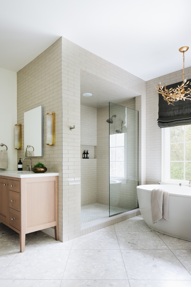 Design ideas for a transitional master bathroom in Grand Rapids with recessed-panel cabinets, light wood cabinets, a freestanding tub, an alcove shower, white tile, ceramic tile, white walls, terrazzo floors, an undermount sink, quartzite benchtops, white floor, an open shower, white benchtops, a double vanity and a freestanding vanity.