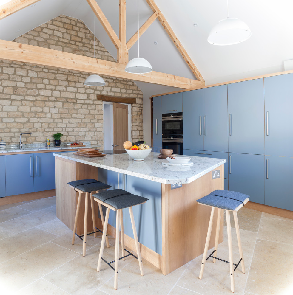 Mid-sized contemporary l-shaped eat-in kitchen in Wiltshire with a single-bowl sink, flat-panel cabinets, grey cabinets, granite benchtops, panelled appliances, limestone floors, with island and beige floor.