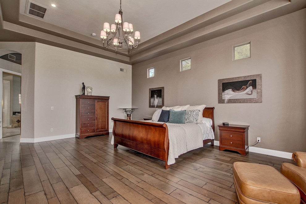 Large contemporary master bedroom in Phoenix with grey walls, medium hardwood floors and no fireplace.