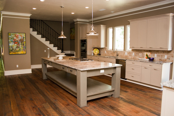 This is an example of an expansive arts and crafts l-shaped open plan kitchen in Atlanta with an undermount sink, raised-panel cabinets, light wood cabinets, granite benchtops, beige splashback, stone tile splashback, stainless steel appliances, medium hardwood floors and with island.