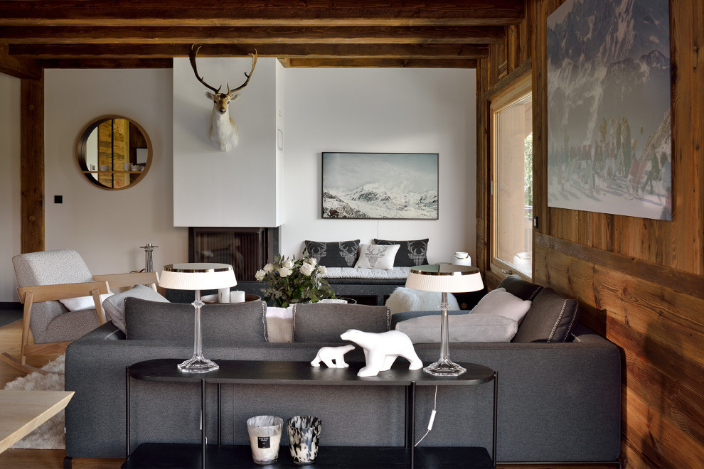 Cette photo montre un grand salon gris et blanc tendance en bois ouvert avec un mur blanc, parquet clair, une cheminée d'angle, un téléviseur fixé au mur et poutres apparentes.