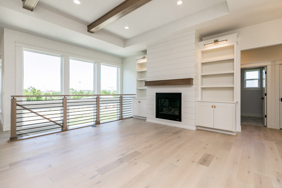 Offenes Modernes Wohnzimmer mit weißer Wandfarbe und Kaminumrandung aus Holzdielen in Cedar Rapids