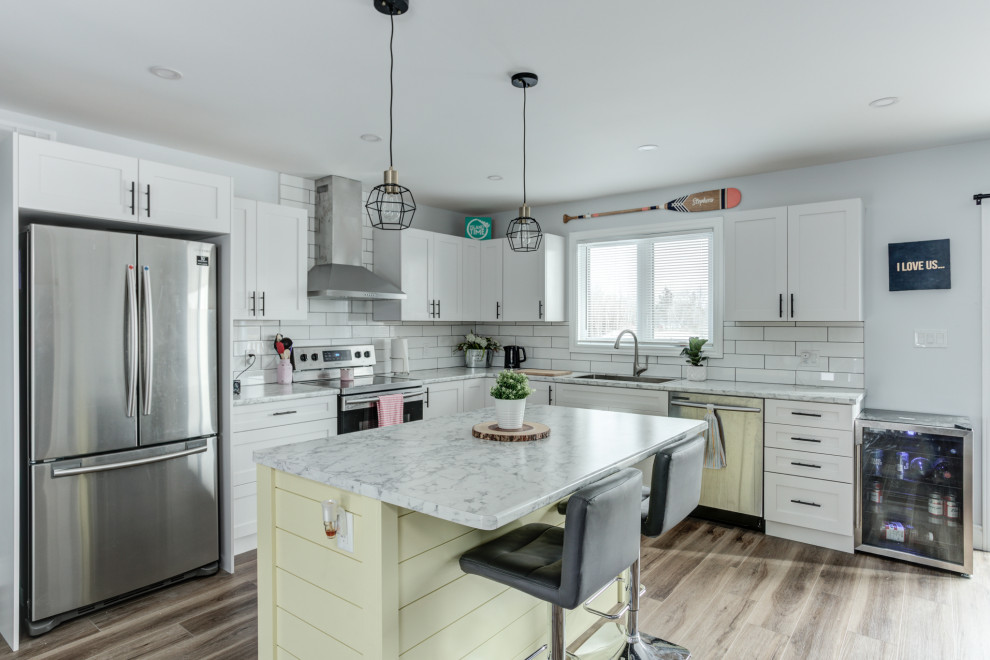 Inspiration for a modern vinyl floor and brown floor eat-in kitchen remodel with shaker cabinets, white cabinets, ceramic backsplash and stainless steel appliances