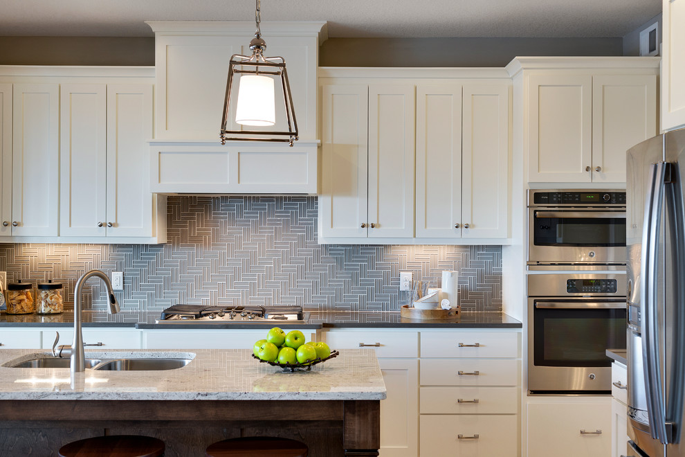 Kitchen - transitional light wood floor kitchen idea in Minneapolis with a double-bowl sink, white cabinets, gray backsplash, ceramic backsplash, stainless steel appliances and an island