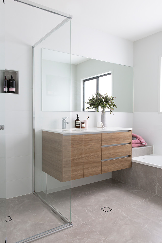 Inspiration for a scandinavian bathroom in Brisbane with flat-panel cabinets, medium wood cabinets, an alcove tub, a corner shower, white walls, an undermount sink, beige floor and white benchtops.