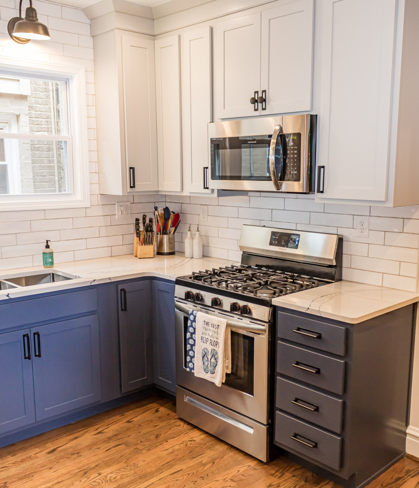 Small transitional u-shaped medium tone wood floor and brown floor eat-in kitchen photo in St Louis with an undermount sink, shaker cabinets, blue cabinets, quartz countertops, white backsplash, subway tile backsplash, stainless steel appliances and white countertops