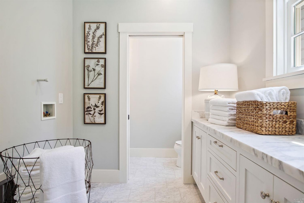 Medium sized farmhouse galley utility room in San Francisco with a submerged sink, shaker cabinets, white cabinets, marble worktops, multi-coloured splashback, marble splashback, white walls, vinyl flooring, a side by side washer and dryer, multi-coloured floors and multicoloured worktops.