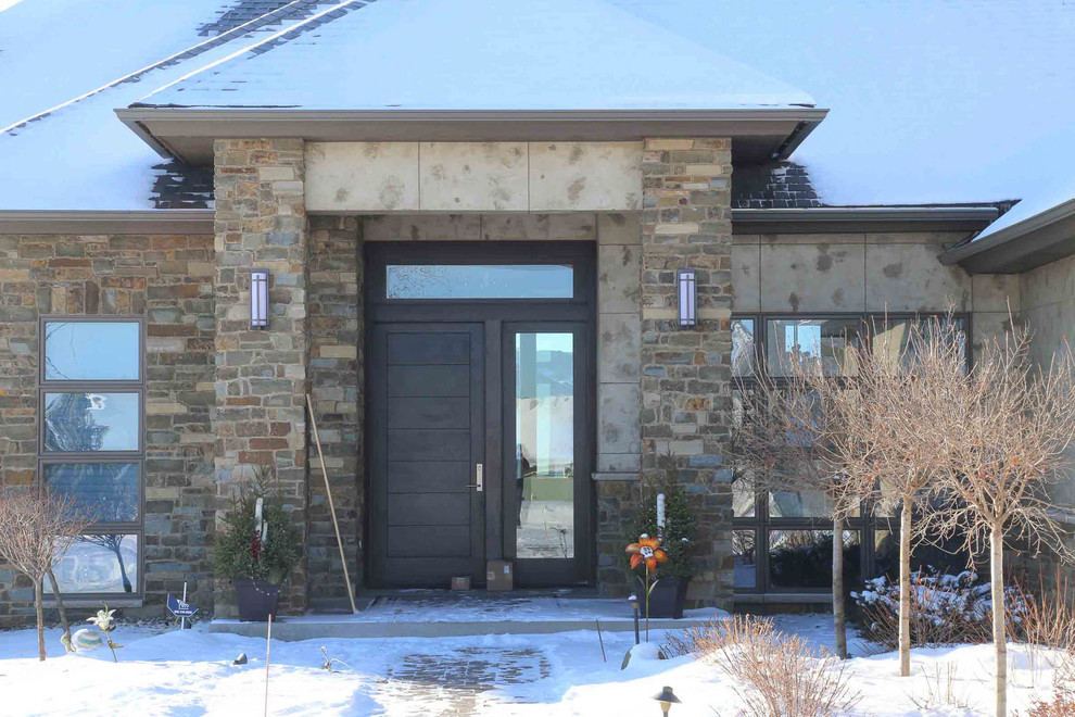 Large transitional two-storey brown house exterior in Other with stone veneer, a hip roof and a shingle roof.