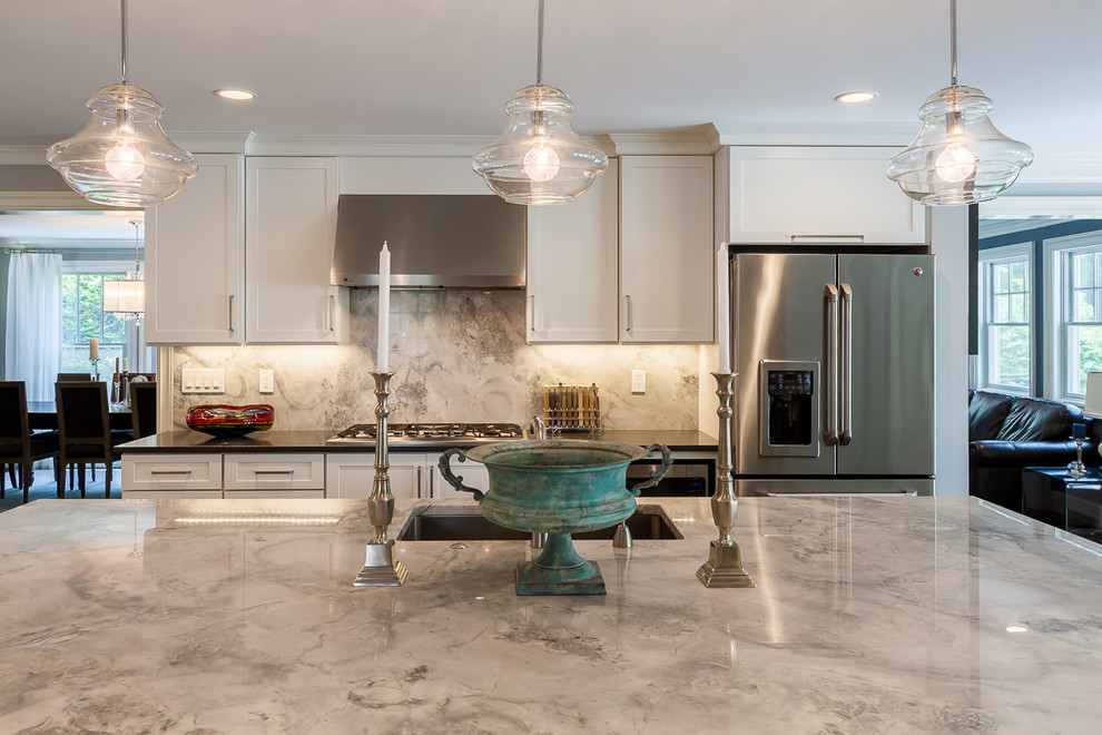 This is an example of a large traditional u-shaped kitchen in Boston with a single-bowl sink, shaker cabinets, granite benchtops, grey splashback, porcelain splashback, stainless steel appliances, dark hardwood floors, with island and grey cabinets.