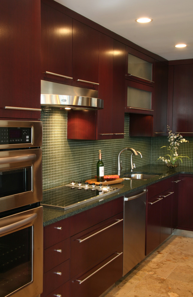 Inspiration for a mid-sized contemporary l-shaped eat-in kitchen in Chicago with an undermount sink, flat-panel cabinets, dark wood cabinets, recycled glass benchtops, green splashback, glass tile splashback, stainless steel appliances, limestone floors and with island.