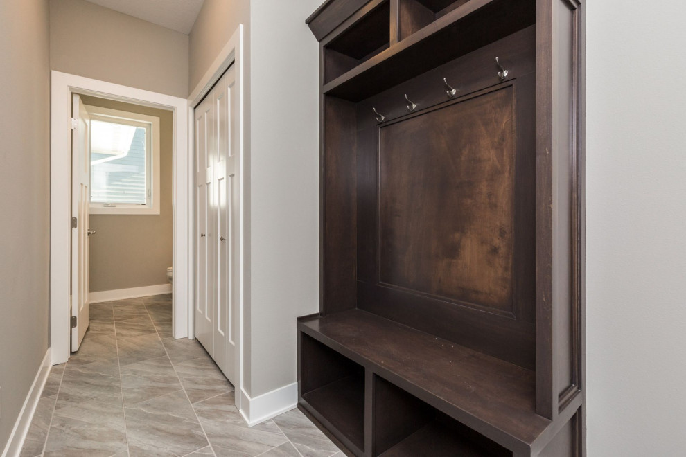 Mudroom - mid-sized transitional ceramic tile and multicolored floor mudroom idea with beige walls and a white front door