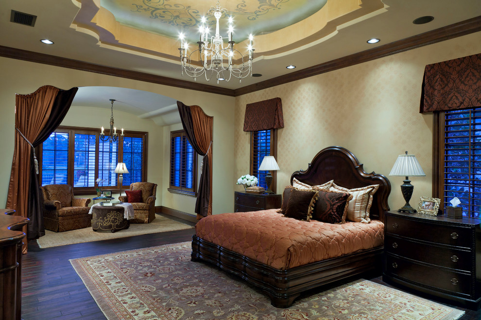 Expansive mediterranean master bedroom in Orlando with beige walls, dark hardwood floors and no fireplace.