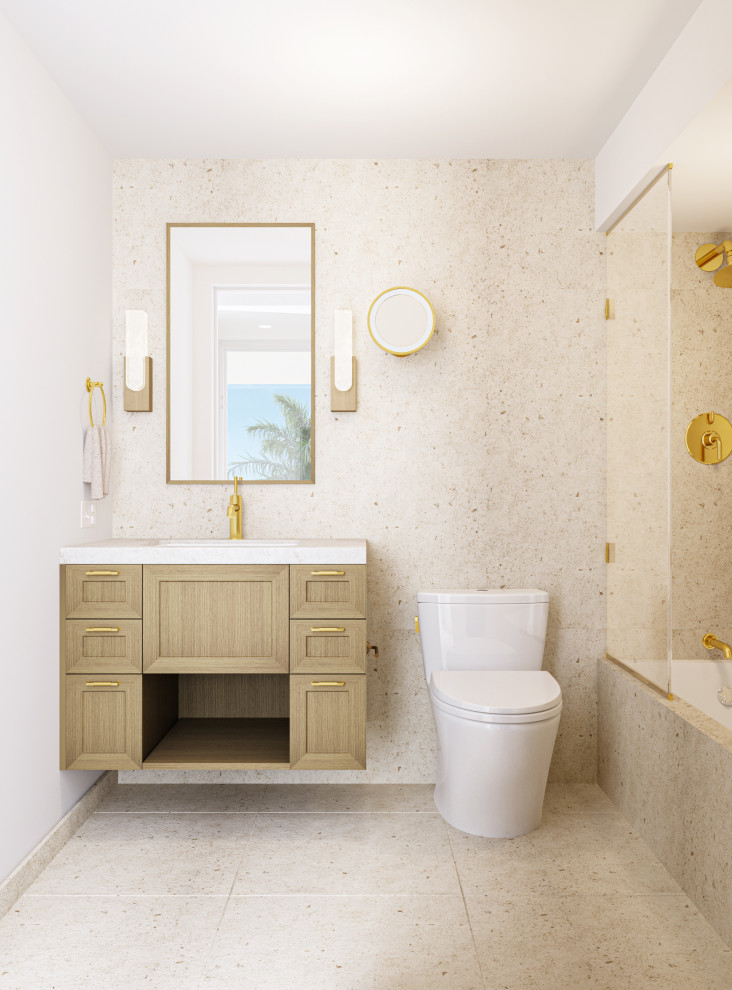 Photo of a mid-sized beach style bathroom in Los Angeles with shaker cabinets, light wood cabinets, an alcove tub, a shower/bathtub combo, a one-piece toilet, beige tile, travertine, white walls, travertine floors, an undermount sink, marble benchtops, beige floor, an open shower, beige benchtops, a single vanity and a floating vanity.