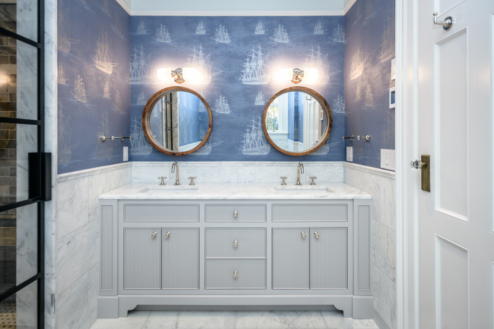 На фото: большая детская ванная комната в классическом стиле с серыми фасадами, полновстраиваемой ванной, душем в нише, серой плиткой, синими стенами, врезной раковиной, мраморной столешницей, белым полом, душем с распашными дверями, белой столешницей, сиденьем для душа, тумбой под две раковины, встроенной тумбой, обоями на стенах и биде с