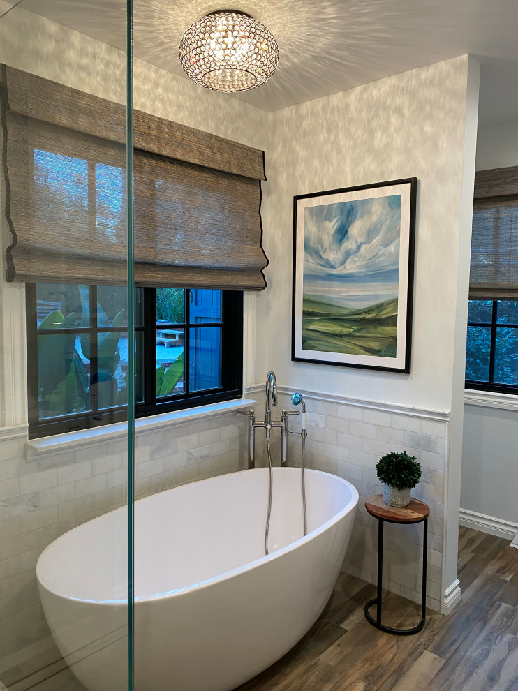 Example of a mid-sized transitional master freestanding bathtub design with a hinged shower door and a built-in vanity