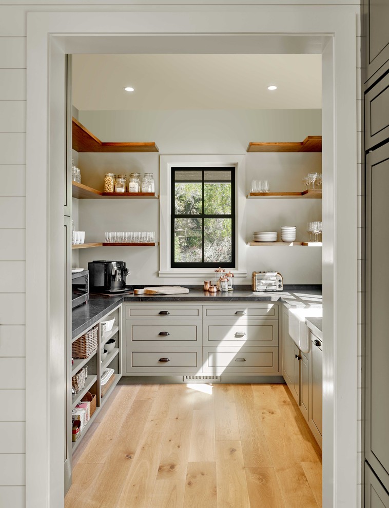 Inspiration for a country u-shaped kitchen pantry in San Francisco with no island, a farmhouse sink, shaker cabinets, grey cabinets, light hardwood floors, beige floor and grey benchtop.