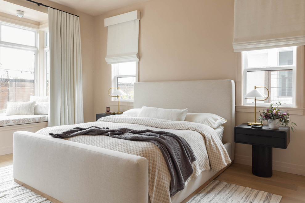 This is an example of a large contemporary master bedroom in San Francisco with beige walls, light hardwood floors and brown floor.