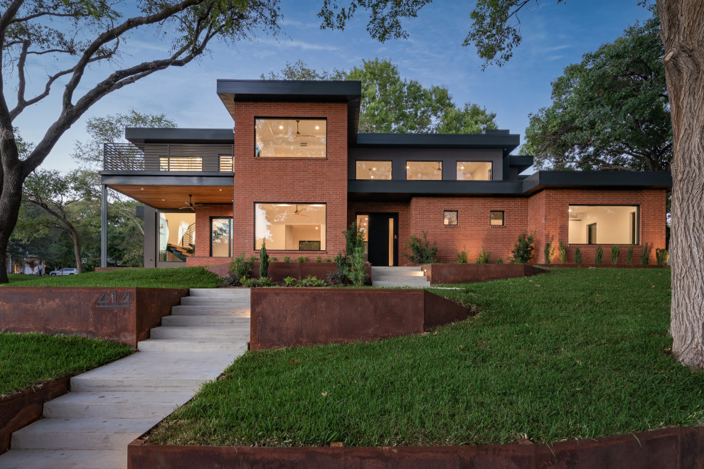 Réalisation d'une façade de maison métallique et rouge vintage à un étage avec un toit plat.