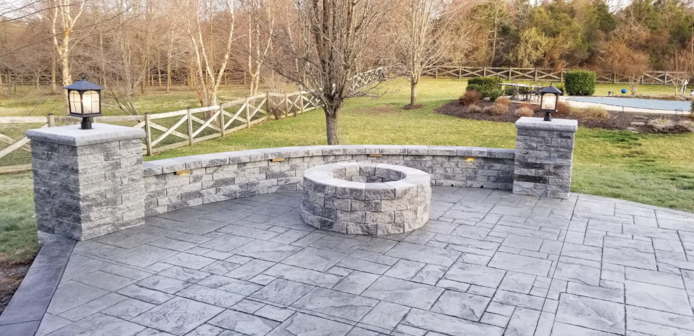 Photo of a large traditional backyard patio in Other with a fire feature and stamped concrete.