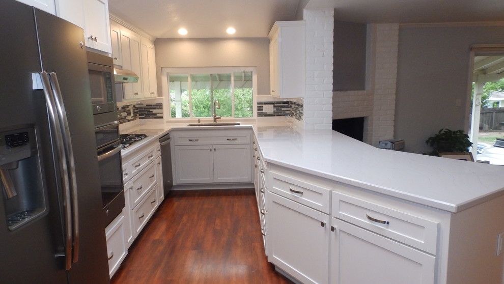 Example of a mid-sized transitional u-shaped dark wood floor eat-in kitchen design in Sacramento with an undermount sink, shaker cabinets, white cabinets, quartz countertops, multicolored backsplash, glass tile backsplash, colored appliances and a peninsula