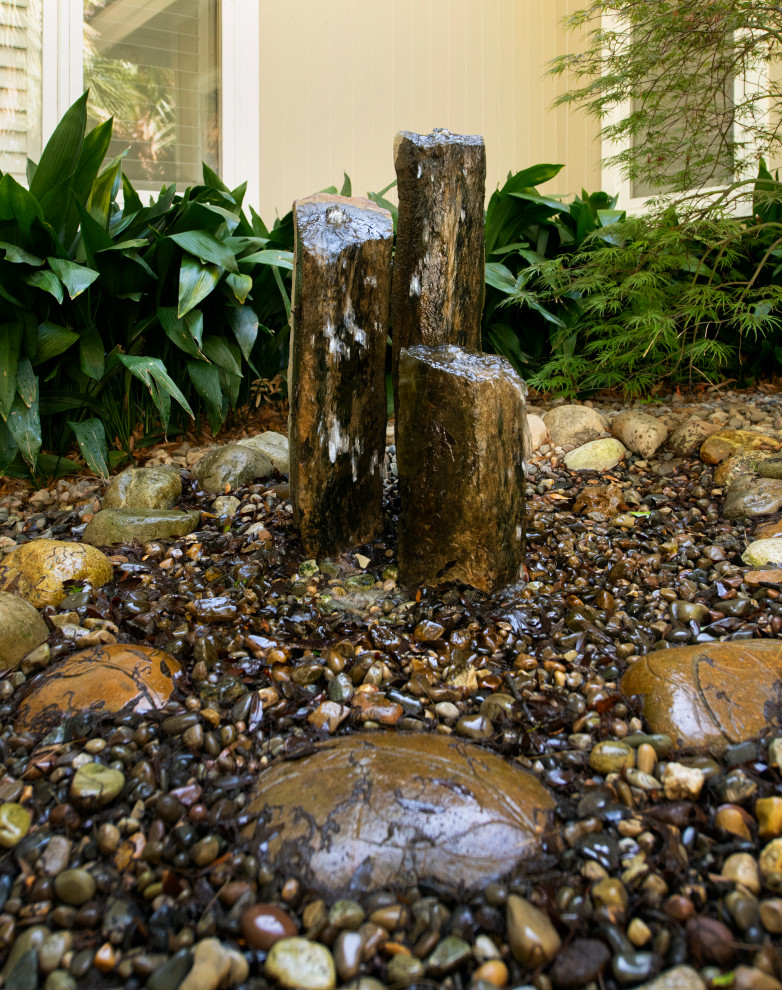 Пример оригинального дизайна: садовый фонтан на заднем дворе в восточном стиле с покрытием из гальки