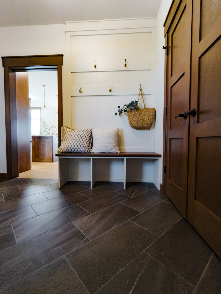 Example of a transitional ceramic tile and brown floor mudroom design