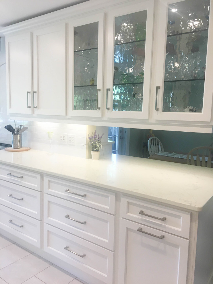 Example of a mid-sized transitional u-shaped porcelain tile and gray floor eat-in kitchen design with an undermount sink, shaker cabinets, white cabinets, quartz countertops, white backsplash, subway tile backsplash, stainless steel appliances, a peninsula and beige countertops