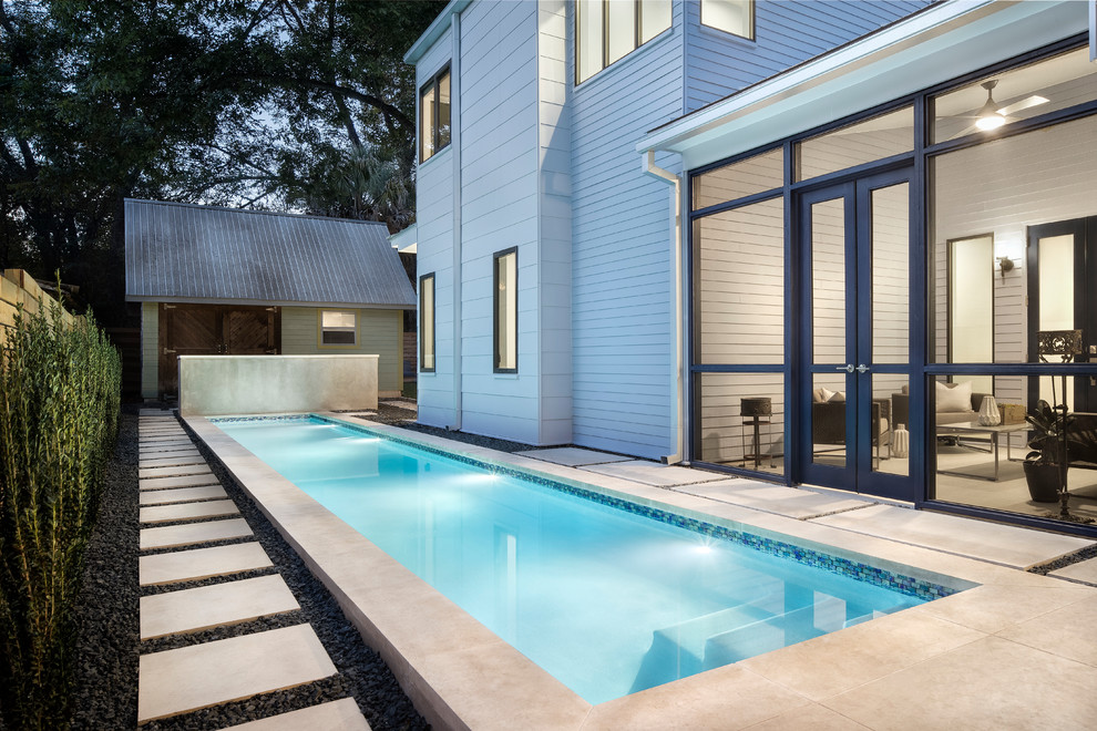 Photo of a large country backyard rectangular lap pool in Austin with concrete pavers.