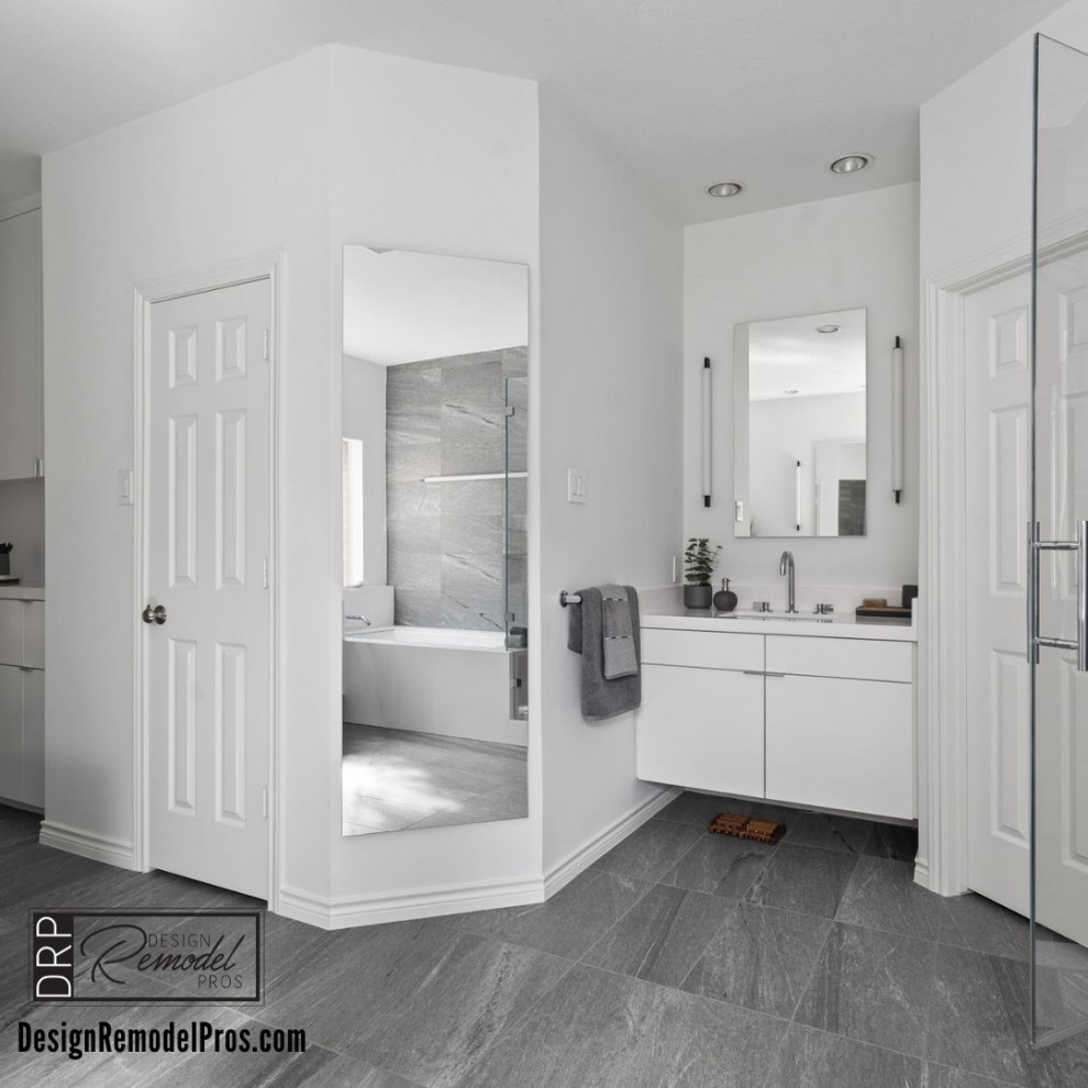 Large minimalist master white tile and porcelain tile porcelain tile, gray floor, double-sink and vaulted ceiling drop-in bathtub photo in Dallas with flat-panel cabinets, white cabinets, a two-piece toilet, gray walls, an undermount sink, quartz countertops, a hinged shower door, a niche and a floating vanity