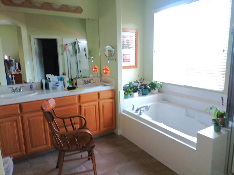 Large transitional master gray tile and porcelain tile vinyl floor, beige floor and double-sink corner shower photo with shaker cabinets, medium tone wood cabinets, a two-piece toilet, green walls, an undermount sink, quartzite countertops, a hinged shower door, beige countertops and a built-in vanity