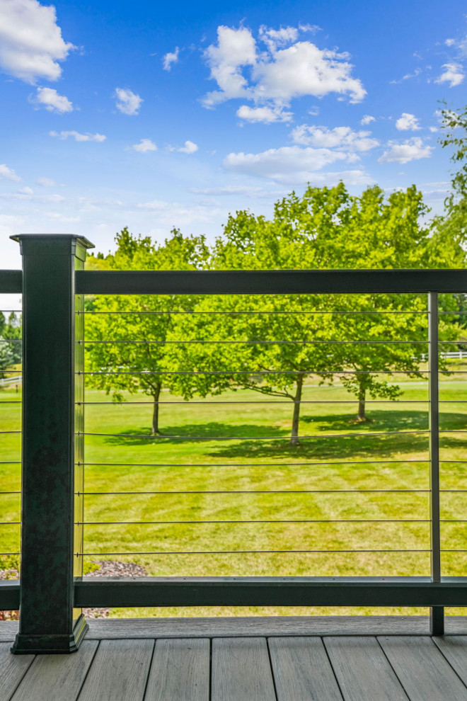 Example of a mid-sized transitional backyard second story cable railing deck design in Columbus with a roof extension