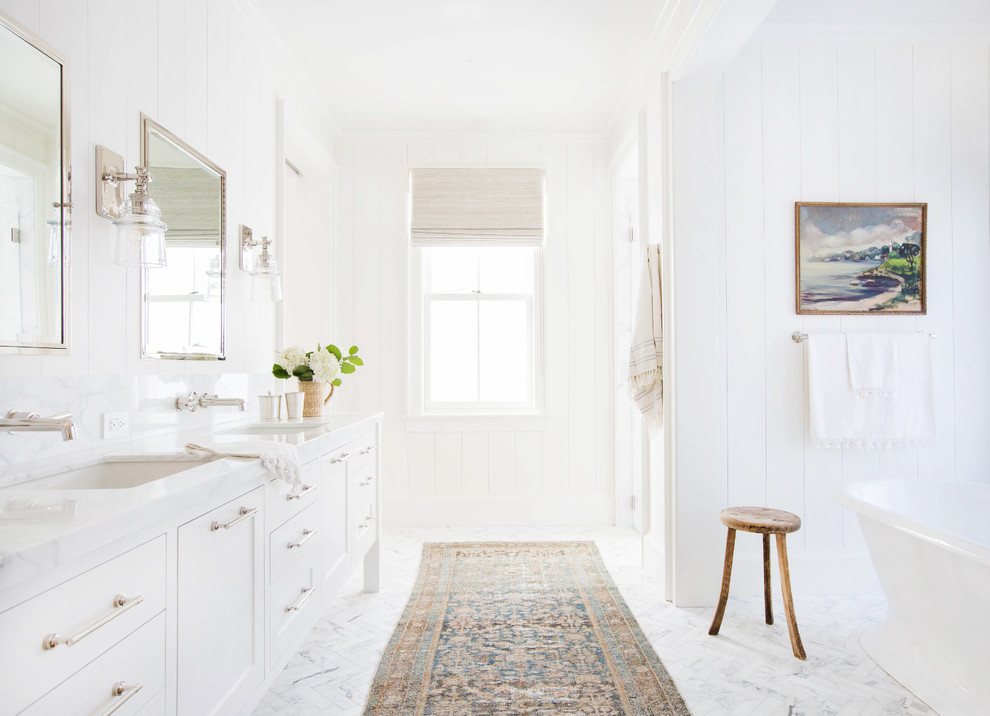Country bathroom in San Francisco with shaker cabinets, white cabinets, a freestanding tub, white walls, marble floors, an undermount sink and white floor.